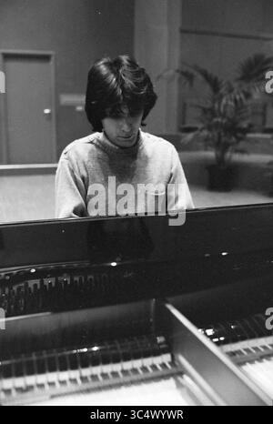 Pianist Egorov im Konzertsaal, Personen singen und Musik, Haarlem, Niederlande, 28-02-1978 Whizgle News, Dutch Desk, Niederlande, 1950-2000 Ein junger Mann spielt einen Flügel, der sich intensiv auf die Tasten konzentriert, wobei die Reflexion des Instruments vor ihm sichtbar ist. Die Umgebung ist geräumig, mit sanftem Licht beleuchtet, was eine Atmosphäre der Konzentration und Kunstfertigkeit schafft. Stockfoto