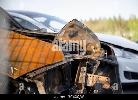 Zerstörte und verbrannte Autos auf dem Schrottplatz nach einem Unfall, die schwere Schäden und Zerstörungen zeigten Stockfoto