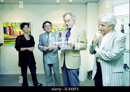 Opening Expo, Heemstede, Heemstede, Niederlande, 11-09-1999 Whizgle News, Dutch Desk, Niederlande, 1950-2000 Eine Gruppe von vier Personen, die sich in einer Kunstgalerie unterhalten, mit lebendigen Gemälden im Hintergrund. Eine Person steht vor dem Lesen einer Zeitung, während die anderen aufmerksam zuhören und einen Moment künstlerischer Wertschätzung und Diskussion zeigen. Stockfoto