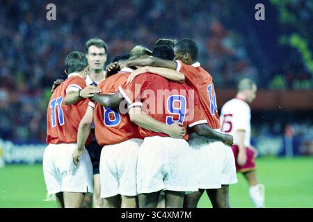 Qualifikationsspiel für die Fußball-Weltmeisterschaft 1998: Die Niederlande spielen gegen Belgien im de Kuip in Rotterdam und gewinnen 3:1., Rotterdam, 06-09-1997 Whizgle News, Dutch Desk, Niederlande, 1950-2000 Eine Gruppe von Spielern in orangefarbenen Trikots feiert nach einem erfolgreichen Spiel eng zusammen mit sichtbarer Kameradschaft und Spannung. Im Hintergrund beobachtet ein Schiedsrichter die Szene, während andere Spieler und Fans verschwimmen, was den freudigen Moment des Teams unterstreicht. Stockfoto