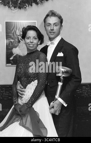 Tanzpaar Ronald und Mieke de Vos, Haarlem, Niederlande, 19-12-1995 Whizgle News, Dutch Desk, Niederlande, 1950-2000 Ein glamouröses Paar posiert zusammen, elegant gekleidet für eine formelle Veranstaltung. Die Frau trägt ein funkelndes, tailliertes Kleid mit komplizierten Details, während der Mann in einem klassischen Smoking eine silberne Trophäe hält. Ihre Ausdrucksformen vermitteln ein Gefühl von Stolz und Feiern. Stockfoto