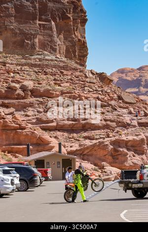 Moab, Utah, USA - 25. Mai 2025: Zwei Personen entladen ein Scrambler-Motorrad von der Rückseite eines Pickup-Trucks Stockfoto