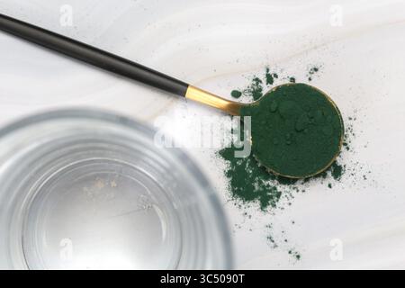 Grünes Pulver Moringa im Löffel. Konzept der Nahrungsergänzung, Diät, Entgiftung, Gesundheitsvorsorge und gesunder Lebensstil. Stockfoto
