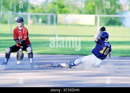 Softball, Unsere Begleiter, Haarlem, Niederlande, 11-05-2001 Whizgle News, Dutch Desk, Niederlande, 1950-2000 Ein Baseballspieler rutscht in die Basis, während ein Fänger sich auf ein Spiel vorbereitet und die Intensität und Spannung eines engen Anrufs auf dem Spielfeld erfasst. Stockfoto