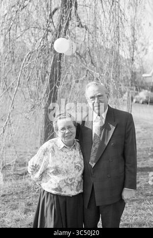 50 Jahre verheiratet, Familie Willemsen, 12-03-1995 Whizgle News, Dutch Desk, Niederlande, 1950-2000 Ein lächelndes älteres Ehepaar steht unter einem sanft wiegenden Baum dicht beieinander und strahlt Wärme und Zuneigung aus. Der Mann trägt eine Brille und ein freundliches Lächeln, während sich die Frau in Bluse und Rock glücklich hinlehnt. Ihre fröhlichen Ausdrucksformen fesseln einen Moment der gemeinsamen Gemeinschaft. Stockfoto