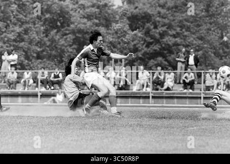 Kennemeren - Swallows, Football Kennemeren, 30-05-1981, Whizgle News, Dutch Desk, Niederlande, 1950-2000 Ein Fußballspieler manövriert gekonnt um einen gleitenden Verteidiger und zeigt schnelle Fußarbeit, während die Zuschauer im Hintergrund aufmerksam beobachten. Der dynamische Moment fängt die Intensität des Spiels und die Energie der Menge ein. Stockfoto