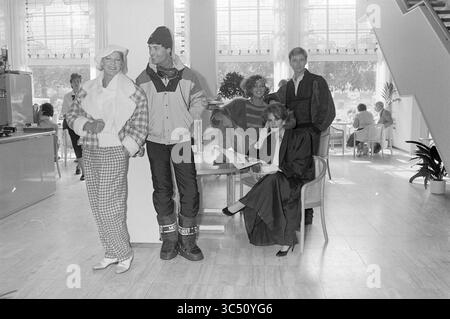 Fashion Show Brinkmann, Fashion, 27-09-1985 Whizgle News, Dutch Desk, Niederlande, 1950-2000 Eine stilvolle Gruppe von Einzelpersonen präsentiert eine Vielzahl modischer Outfits in einem geräumigen, modernen Ambiente, wobei einige sich mit Gesprächen beschäftigen und andere mit Lesen beschäftigt. Die helle Umgebung verfügt über große Fenster und moderne Möbel, die eine Mischung aus lässiger und eleganter Kleidung hervorheben. Stockfoto