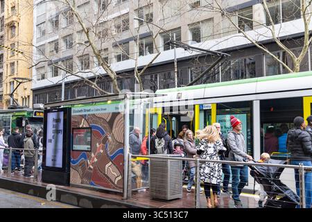 Die Straßenbahn Melbourne, Victoria, Australien, Yarra hält an der Straßenbahnhaltestelle Elizabeth Street, wo Passagiere auf das Einsteigen in die Straßenbahn warten, innerhalb der Freiverkehrszone Stockfoto