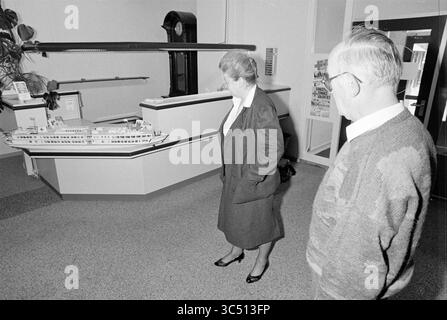 Übergabe des Henry Dunant Roten Kreuzes an Burg. Schmitz [Schiff], Rotes Kreuz, Rotes Kreuz Krankenhaus, 07-03-1990 Whizgle News, niederländischer Schreibtisch, Niederlande, 1950-2000 Ein Paar beobachtet Ein detailliertes Modell eines Schiffes, das in einem Museum ausgestellt wird, und fängt ihre Neugier und ihr Interesse ein, während sie näher heranrücken, um die Handwerkskunst zu untersuchen. Stockfoto