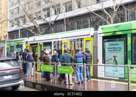 Die Straßenbahn Melbourne, Victoria, Australien, Yarra hält an der Straßenbahnhaltestelle Elizabeth Street, wo Passagiere auf das Einsteigen in die Straßenbahn warten, innerhalb der Freiverkehrszone Stockfoto