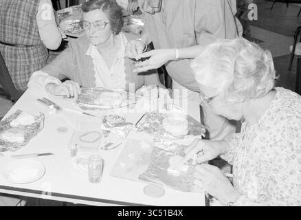 Landfrauen machen Gegenstände aus Teig, Hobby, Frauen, 13-11-1984 Whizgle News, Dutch Desk, Niederlande, 1950-2000 zwei ältere Frauen sitzen an einem Tisch, die eine kreative Tätigkeit ausüben, bei der sie Gegenstände mit vor ihnen liegenden Materialien herstellen. Eine Frau konzentriert sich auf ihre Arbeit, während die andere anscheinend Orientierungshilfe bietet, mit mehreren Werkzeugen und farbigen Materialien, die über den Tisch verteilt sind. Die Atmosphäre deutet auf ein gemeinschaftliches und kollaboratives Umfeld hin. Stockfoto