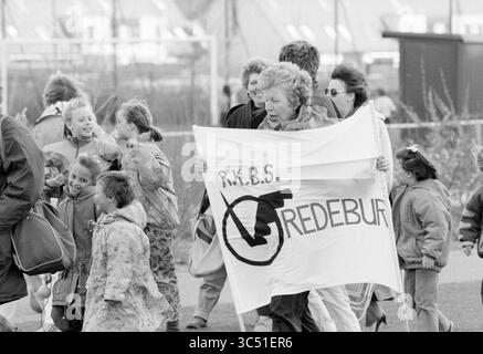 Osterfußball, Hoofddorp, Fußball, 11-04-1990 Whizgle News, Dutch Desk, Niederlande, 1950-2000 Eine Gruppe von Einzelpersonen, darunter Kinder und Erwachsene, marschiert zusammen mit einem großen Banner, das sich für eine Sache einsetzt. Die Atmosphäre ist von einem Gefühl der Entschlossenheit und Gemeinschaft erfüllt, wenn sie sich auf ein Ziel konzentrieren, wobei einige Menschen lächeln und andere sich in Gesprächen engagieren. Stockfoto
