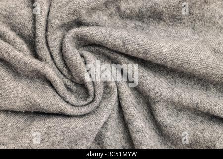 Eine detaillierte Nahaufnahme eines weichen, grauen Materials, das seine Textur und Falten zeigt. Stockfoto