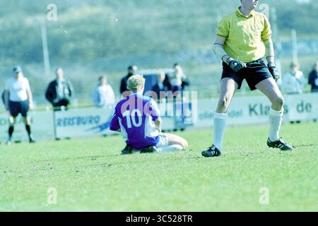 Football, Stormvogels - KGB, IJmuiden, IJmuiden, Niederlande, 22-03-2003 Whizgle News, Dutch Desk, Niederlande, 1950-2000 Ein Spieler, der ein blaues Trikot mit der Nummer 10 trägt, sitzt sichtbar frustriert auf dem Spielfeld, während ein Torwart in einem gelben Trikot in der Nähe steht. Die Szene fängt die Intensität eines Wettkampfes ein, während andere Spieler und Zuschauer im Hintergrund stehen. Stockfoto