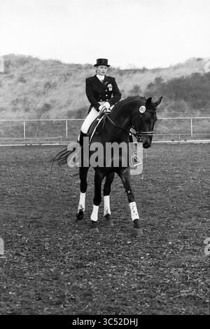 Daniëlle Keur, Dressur, 13-02-1995 Whizgle News, Dutch Desk, Niederlande, 1950-2000 Ein Reiter in formeller Reitkleidung tritt auf einem polierten schwarzen Pferd in einer Dressurarena auf und zeigt sein Können und seine Anmut vor einer natürlichen Kulisse. Stockfoto