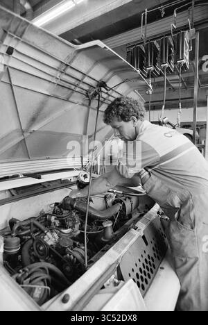 Automechaniker Citroën, Haarlem, Niederlande, 25-07-1991 Whizgle News, Dutch Desk, Niederlande, 1950-2000 Ein erfahrener Mechaniker arbeitet fleißig am Motor eines Fahrzeugs, konzentriert sich auf die Feinabstimmung von Komponenten, während er in einer Werkstatt von Werkzeugen und Ausrüstung umgeben ist. Stockfoto
