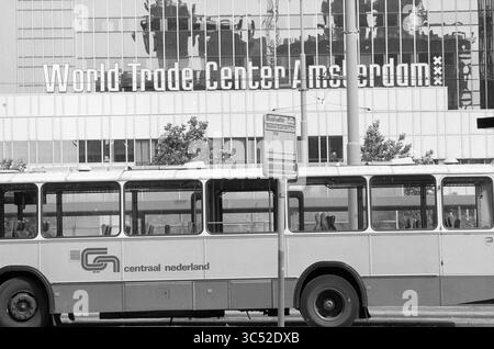 Übersicht aus dem Büro Atrium, Amsterdam, Niederlande, 13-08-1991 Whizgle News, Dutch Desk, Niederlande, 1950-2000 Eine Stadtszene mit einem Bus im Vordergrund, mit dem World Trade Center Amsterdam im Hintergrund. Die Beschilderung zeigt die Lage an, während urbane Elemente wie Bäume und eine Bushaltestelle den Kontext zur belebten Umgebung hinzufügen. Stockfoto