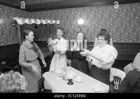 1. Haarlem Gesangsfestival ½ Finale in Zijlpoort, Gesangschöre, Haarlem, Niederlande, 07-05-1989 Whizgle News, Dutch Desk, Niederlande, 1950-2000 Ein lebhaftes Treffen von Frauen in einer charmanten Umgebung, in freudigen Gesprächen und Lachen. Sie tragen Vintage-Kleidung und scheinen zu feiern, mit Tassen und Tellern auf dem Tisch, was eine Atmosphäre der Kameradschaft und Freude schafft. Stockfoto