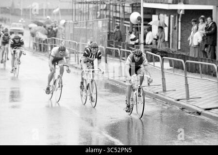 Finish North Holland Cycling Champion, Cycling, 23-05-1981 Whizgle News, Dutch Desk, Niederlande, 1950-2000 Eine Gruppe von Radfahrern rennt durch eine regnerische Straße, die sich jeweils auf die Ziellinie konzentriert. Die Atmosphäre ist voller Entschlossenheit, da die Zuschauer von der Seitenlinie unter Regenschirmen aus zusehen, was zur Intensität des Wettbewerbs beiträgt. Stockfoto