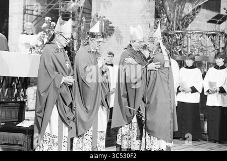 Bischof Bomers und Weihbischof Lescrauwaert, RK Bavo, Haarlem, Weihe, römisch-katholische Kirche, Haarlem, Niederlande, 14-01-1984 Whizgle News, Dutch Desk, Niederlande, 1950-2000 versammelt sich Eine Gruppe von vier Bischöfen in aufwendiger zeremonieller Kleidung in einem feierlichen Rahmen, um einen Moment der Ehrfurcht und Einheit während einer religiösen Zeremonie zu demonstrieren, mit kirchlichen Verzierungen und Chormitgliedern im Hintergrund. Stockfoto