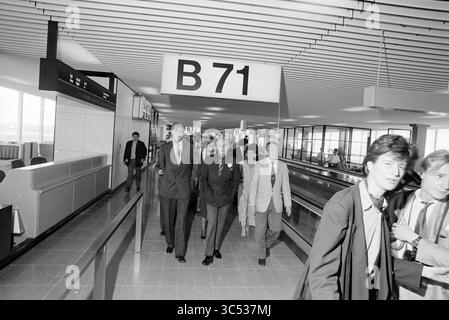 Eröffnung der Verlängerung von Pier B in Schiphol durch Prince Bernhard., Schiphol, 03-05-1990 Whizgle News, Dutch Desk, Niederlande, 1950-2000 Eine Gruppe gut gekleideter Personen navigiert durch ein modernes Flughafenterminal und geht zu einem mit der B71 gekennzeichneten Flugsteig. Die Atmosphäre ist geschäftig, mit Reisenden und Flughafenpersonal im Hintergrund, die ein Gefühl von Bewegung und Aktivität reflektieren. Stockfoto