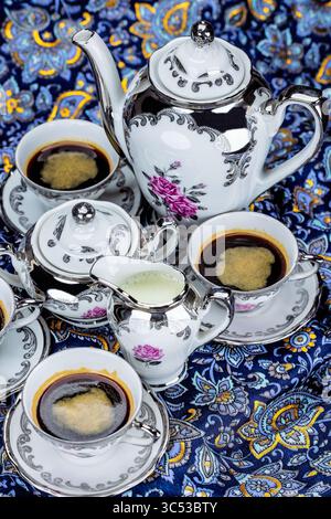 Set aus Vintage Porzellan Kaffeetassen auf farbenfrohem abstraktem Hintergrund, von oben gesehen Stockfoto