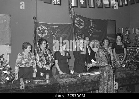 Empfang T.V.IJ., 75. Jahrestag [IJmuiden Gymnastikverband], Empfänge, Gymnastik, 01-10-1976 Whizgle News, Dutch Desk, Niederlande, 1950-2000 Ein formelles Treffen mit einer Gruppe von Männern und Frauen, die in eleganter Kleidung gekleidet sind, an einem Handschlag und einem Gespräch teilnahmen. Die Umgebung ist mit festlichen Bannern und internationalen Flaggen dekoriert, die ein Gefühl von Gemeinschaft und Feier wecken. Blumenarrangements und Tischdekorationen sorgen für die Atmosphäre der Veranstaltung. Stockfoto