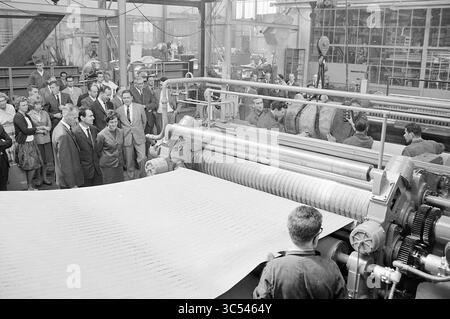 Transfer der 100. Wellpappenmaschine bei Conrad & Stork Hijsch nach Italian, Haarlem, Nederland, 15-07-1963 Whizgle News, Dutch Desk, Niederlande, 1950-2000 Eine Gruppe von Menschen beobachtet eine große industrielle Druckmaschine in Betrieb, mit großen Papierrollen und Maschinen im Hintergrund. Die Szene fängt einen Moment der Industrie und Innovation ein und zeigt die komplizierten Fertigungsprozesse. Stockfoto