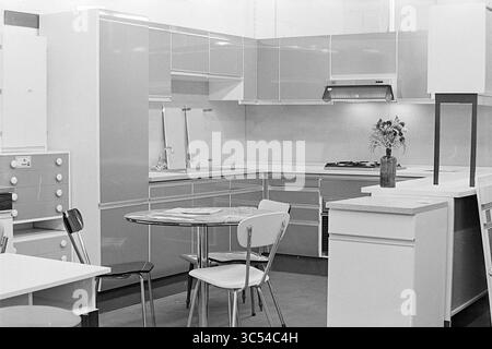 Intr. Bowl-Dauer auf dem Rijksstraatweg, Interior, Haarlem, Rijksstraatweg, Niederlande, 27-09-1974 Whizgle News, Dutch Desk, Niederlande, 1950-2000 Eine moderne Küche mit eleganten Schränken und stilvollem Layout, komplett mit einem runden Esstisch, umgeben von minimalistischen Stühlen. Eine kleine Blumenvase verleiht dem modernen Design einen Hauch Wärme. Stockfoto