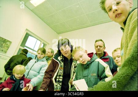 Tag der offenen Tür Stedelijk Gymnasium, Haarlem, Niederlande, 06-02-2003 Whizgle News, Dutch Desk, Niederlande, 1950-2000 Eine Gruppe von Menschen, darunter Erwachsene und Kinder, versammelt sich in einem hellen, geräumigen Raum, um sich zu unterhalten und etwas Interessantes zu betrachten. Einige Menschen konzentrieren sich auf die anstehende Aufgabe, während andere neugierig oder kontemplativ wirken. Die Atmosphäre ist lebendig und gemeinschaftlich, was einen Moment der gemeinsamen Erfahrung widerspiegelt. Stockfoto