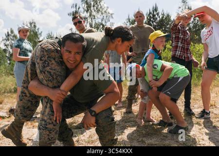 8. Juni 2019 – Lettland – US-Marine-Sgt. Justin Cortez, ein Spezialist für zivile Angelegenheiten, und Sgt. Tracey Rodriguez, ein Kampfingenieur, beide zusammen mit der 22. Marine Expeditionstruppe, demonstrieren, wie man lettischen Scouts bei einem Besuch in Jurmala, Lettland, die am 8. Juni 2019 mit Feuerwehrmännern ausgestattet sind. Marines besuchten die Sea Scouts, um internationale Beziehungen aufzubauen und das Bewusstsein für die bevorstehende NATO-Übung Baltic Operations (BALTOPS) zu schärfen. BALTOPS ist die wichtigste jährliche, auf den Seeverkehr ausgerichtete Übung im Ostseeraum und eine der größten Übungen in Nordeuropa zur Erhöhung der Flexibilität Stockfoto