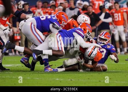 30. Dezember 2019: Virginia Cavaliers Running Back Wayne Taulapapa (21) wird von Florida Gators Defensive Lineman Luke Ancrum (98), Center, und Linebacker David Reese II (33), rechts, während des Capital One Orange Bowl - NCAA Football Spiels im Hard Rock Stadium in Miami Gardens, Florida, niedergeschlagen. Florida besiegte Virginia mit 36:28. Mario Houben/CSM(Kreditbild: &Copy; Mario Houben/CSM via ZUMA Wire) Stockfoto