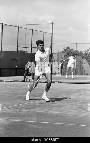 Tennis Brederode III, Jaidip Mukerjea-Tom Okker, Santpoort, 197-07-1965 Whizgle News, Dutch Desk, 30 Niederlande, 1950-2000 Ein Tennisspieler im mittleren Schwung bereitet sich auf einen Platz vor und zeigt dynamische Bewegungen und Fokussierung. Im Hintergrund wartet ein anderer Spieler auf seinen Zug, während die Zuschauer von der Seitenlinie aus beobachten. Stockfoto