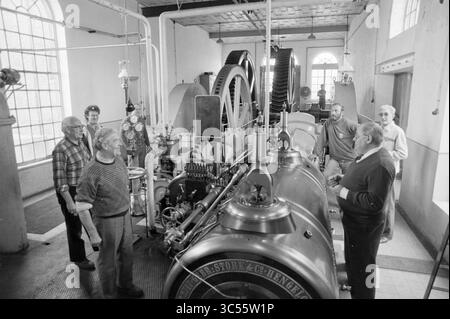 Wiedereröffnung der Dampfpumpenstation auf halbem Wege, Eröffnung, Öffnungen, Inbetriebnahme, Dampfpumpenstation und Dampfpumpenstation, Halfweg, 01-04-1989 Whizgle News, Dutch Desk, Niederlande, 1950-2000 Eine Gruppe von Männern versammelt sich in einer Werkstatt um eine große Industriemaschine und diskutiert deren Mechanismen und Funktionsweise. Die Szene fängt eine Mischung aus Neugier und Kameradschaft unter den einzelnen Personen ein, während sie mit der Maschine umgehen. Stockfoto