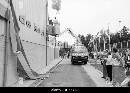 Eröffnung des Sportgeschäfts Bennebroek, Eröffnung, Eröffnung, Eröffnung, Sport- und Sportwoche, Bennebroek, 25-08-1989 Whizgle News, Dutch Desk, Niederlande, 1950-2000 Eine große Menschenmenge versammelt sich, als ein Fahrzeug mit Aufzug aufsteigt, um bunte Ballons freizulassen, während die Zuschauer gespannt auf die Enthüllung einer neuen Anlage mit einem markanten Schild warten. Flaggen aus verschiedenen Nationen sind in der Nähe zu sehen, was die festliche Atmosphäre der Veranstaltung unterstreicht. Stockfoto