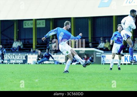 Fußball: Stormvogels - DWS, IJmuiden, Niederlande, 09-10-1999 Whizgle News, Dutch Desk, Niederlande, 1950-2000 Ein Fußballspieler in einem blauen Trikot führt einen kräftigen Kick auf dem Spielfeld aus, bei dem Teamkollegen und Gegner während eines Wettkampfs in Aktion sind. Die Fans sind im Hintergrund zu sehen und beobachten, wie sich das intensive Spiel entfaltet. Stockfoto