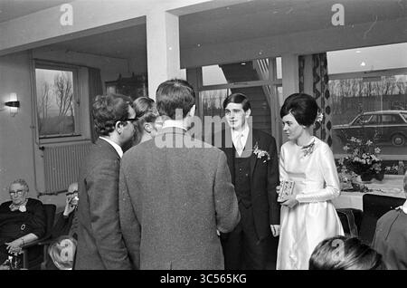 Wedding Theo Reitsma Beverwijk, Empfänge, 06-01-1965 Whizgle News, Dutch Desk, Niederlande, 1950-2000 Eine Gruppe elegant gekleideter Personen versammelt sich in einem warmen, einladenden Raum, um einen freudigen Anlass zu feiern. Die Braut trägt ein schlichtes, aber elegantes Kleid und spricht mit Gästen, während sie Lächeln und Gespräche teilen, während einige andere mit Glücksgefühlen und Kameradschaft zuschauen. Die Atmosphäre ist erfüllt von einem Gefühl der Gemeinschaft und des Feierns. Stockfoto