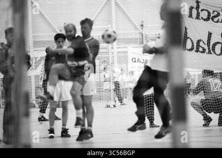 Fußball + Volleyballturnier HDL, 17-06-1994 Whizgle News, Dutch Desk, Niederlande, 1950-2000 Eine dynamische Szene aus einem Fußballspiel, in der Spieler in Aktion sind, während man versucht, den Ball zu kicken, während andere in der Nähe positioniert sind. Die Intensität des Spiels ist spürbar und die Spieler konzentrieren sich auf Strategie und Teamarbeit in einem Turnsaal. Stockfoto