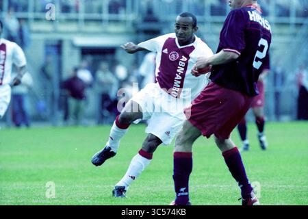 Fußball: Haarlem - Ajax, 16-07-2002 Whizgle News, Dutch Desk, Niederlande, 1950-2000 Ein dynamischer Moment auf dem Fußballfeld, in dem ein Spieler in weiß-roter Uniform den Ball geschickt an einem Gegner mit braunem Kit vorbeidribbelt. Die Atmosphäre ist voller Wettbewerbsenergie, während die Spieler auf dem grasbewachsenen Feld navigieren. Stockfoto