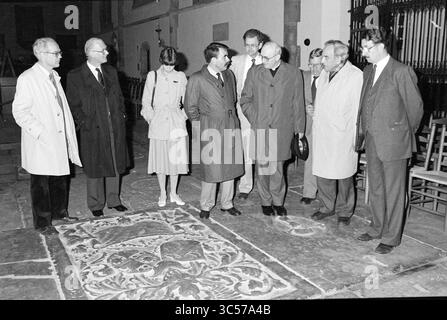 Bischof Bomers besucht St. Bavo, Kirchen, römisch-katholische Kirche, 20-05-1984 Whizgle News, Dutch Desk, Niederlande, 1950-2000 Eine Gruppe von Einzelpersonen, die in formeller Kleidung gekleidet sind, versammelt sich um ein dekoratives Steinelement auf dem Boden, um an Diskussionen teilzunehmen. Die Umgebung scheint ein historischer oder architektonischer Raum zu sein, mit bemerkenswerten Merkmalen im Hintergrund. Stockfoto