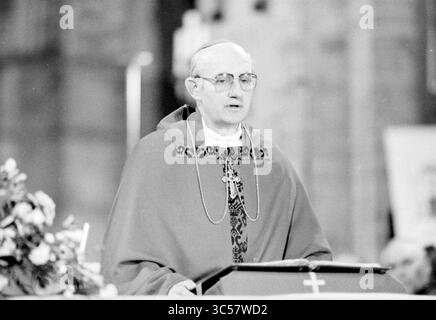 Bischof Bomers und Weihbischof Lescrauwaert, RK Bavo, Haarlem, Weihe, römisch-katholische Kirche, Haarlem, Niederlande, 14-01-1984 Whizgle News, Dutch Desk, Niederlande, 1950-2000 Ein Geistlicher hält eine Predigt von einem Podium, trägt traditionelle kirchliche Gewänder und Gläser, vor dem Hintergrund floraler Arrangements und religiöser Symbole. Stockfoto