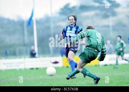 Fußball: Stormvogels - KBV, IJmuiden, IJmuiden, Niederlande, 14-03-1998 Whizgle News, Dutch Desk, Niederlande, 1950-2000 Ein Fußballspieler in einem grünen Trikot bereitet sich darauf vor, den Ball zu schlagen, während ein Gegner in einem blau-schwarz gestreiften Hemd von hinten zusieht. Die Szene fängt die Intensität und Spannung eines Wettkampfes auf einem grasbewachsenen Feld ein. Stockfoto