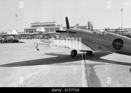 Ausstellung von Flugzeugen aus dem Zweiten Weltkrieg, Schiphol, Schiphol, Schiphol, 05-05-1980 Whizgle News, Dutch Desk, Niederlande, 1950-2000 Ein klassisches Kampfflugzeug steht auf einem Asphalt und zeigt sein elegantes Design und seine markanten Markierungen, während sich eine Menge Zuschauer im Hintergrund in der Nähe eines großen Gebäudes versammelt, wahrscheinlich einer Flugschau oder einer Flugveranstaltung. Stockfoto