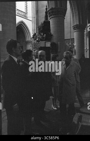 Bischof Bomers besucht St. Bavo, Kirchen, römisch-katholische Kirche, 20-05-1984 Whizgle News, Dutch Desk, Niederlande, 1950-2000 Eine Gruppe von Menschen führt Gespräche in einem großen, historischen Gebäude mit hohen Bögen und komplizierter Architektur im Hintergrund. Einige Menschen scheinen aufmerksam zuzuhören, während andere beim Sprechen Gesten geben. Stockfoto