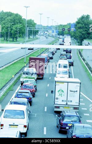 Verkehrsstau für Velsertunnel, 15-08-2001 Whizgle News, Dutch Desk, Niederlande, 1950-2000 Eine geschäftige Autobahnszene mit einer langen Reihe von Fahrzeugen, darunter Autos und Lkw, mit Schildern in der Entfernung und Grün am Straßenrand. Der Verkehr scheint auf einer Spur zum Stillstand zu kommen, während andere Fahrspuren sich bewegen. Stockfoto