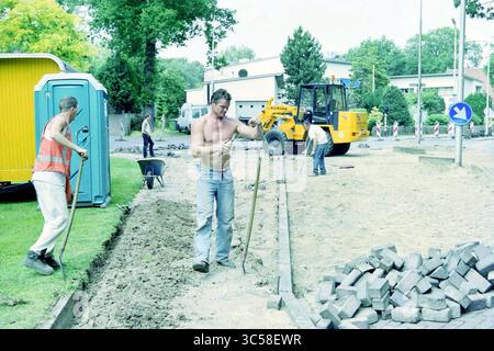 Arbeit in Driehuis, Driehuis, 15-06-2003 Whizgle News, Dutch Desk, Niederlande, 1950-2000 Eine Gruppe von Arbeitnehmern beschäftigt sich mit dem Bau von Straßen, mit Schaufeln und schweren Maschinen und legt Pflastersteine ab. Die Szene ist voll von Aktivitäten und zeigt die gemeinsame Bemühung, den Bereich zu verbessern. Stockfoto