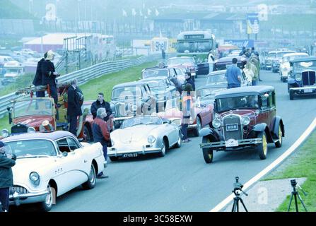 Oldtimer Record Versuch, Zandvoort, Zandvoort, 10-05-2002 Whizgle News, Dutch Desk, Niederlande, 1950-2000 Eine pulsierende Szene klassischer Automobile, die auf einer Rennstrecke aufeinanderreiht, umgeben von begeisterten Zuschauern, die den Moment festhalten. Verschiedene Oldtimer, darunter ein elegantes Cabriolet und mehrere legendäre Modelle, schaffen eine nostalgische Atmosphäre, während die Teilnehmer die Auswahl an Fahrzeugen bewundern. Stockfoto