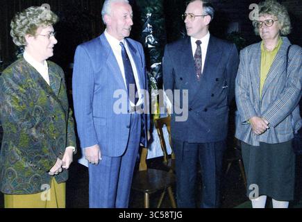 Gruppe und Rezeption Ven, 06-11-1990 Whizgle News, Dutch Desk, Niederlande, 1950-2000 Eine Gruppe von vier Personen steht zusammen und führt Gespräche. Sie tragen formelle Kleidung, zwei Männer tragen Anzüge und Krawatten, während die Frauen stilvolle Blusen und Jacken tragen. Ihre Ausdrucksformen vermitteln eine Mischung aus Wärme und Aufmerksamkeit und deuten auf eine sinnvolle Diskussion oder Zusammenkunft hin. Stockfoto