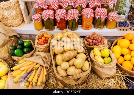 Obst, Gemüse und Gläser mit eingelegten Artikeln auf dem lebhaften Bauernmarkt im Herbst. Stockfoto