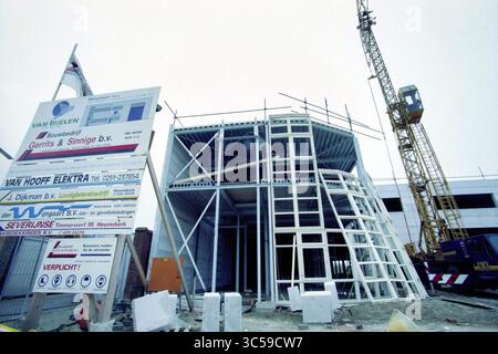 Neubauunternehmen Van Beelen IJmuiden, IJmuiden, Niederlande, 30-11-1998 Whizgle News, Dutch Desk, Niederlande, 1950-2000 Eine Baustelle mit einem teilweise gebauten Gebäude mit einzigartigem architektonischem Design. Es sind verschiedene Stützbalken und Gerüste sowie ein großes Bauschild mit Details zum Projekt und den beteiligten Unternehmen sichtbar. Im Hintergrund steht ein Kran, der auf laufende Arbeiten und Entwicklungen hinweist. Stockfoto